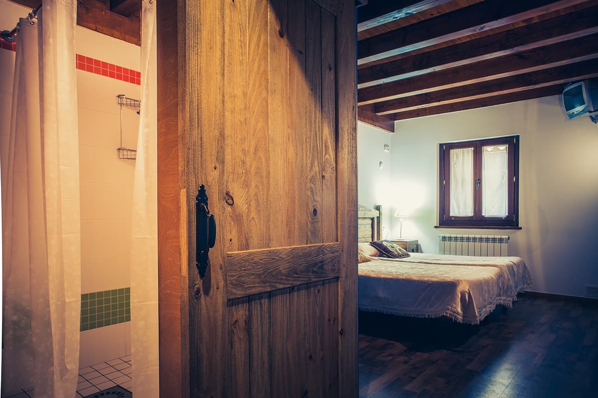 Puerta de madera del pasillo, con una habitación al fondo