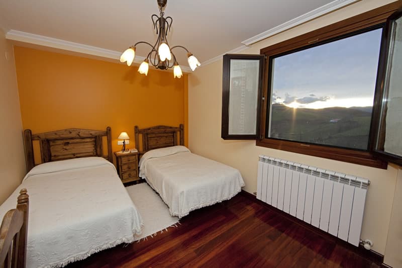 Habitación de dos camas individuales con ventanal a la costa