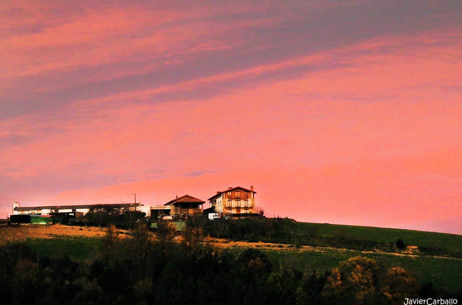 El caserío recortado sobre el cielo rosado del atardecer
