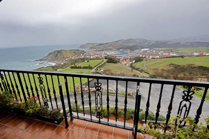 Terraza del apartamento con barandilla de forja sobre los prados, el Flysch y el puerto de Zumaia